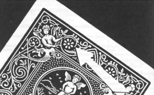 Photo of a hand holding a King of Hearts and Ace of Spades with casino chips on a table
